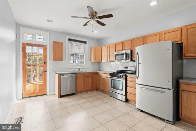 a kitchen with stainless steel appliances granite countertop a refrigerator sink and stove