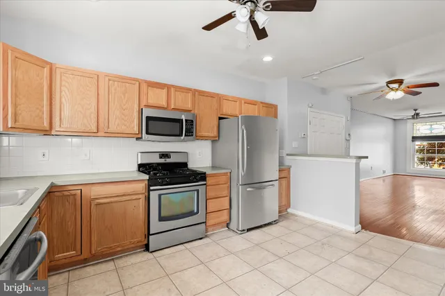a kitchen with stainless steel appliances granite countertop a refrigerator a stove top oven a sink and dishwasher