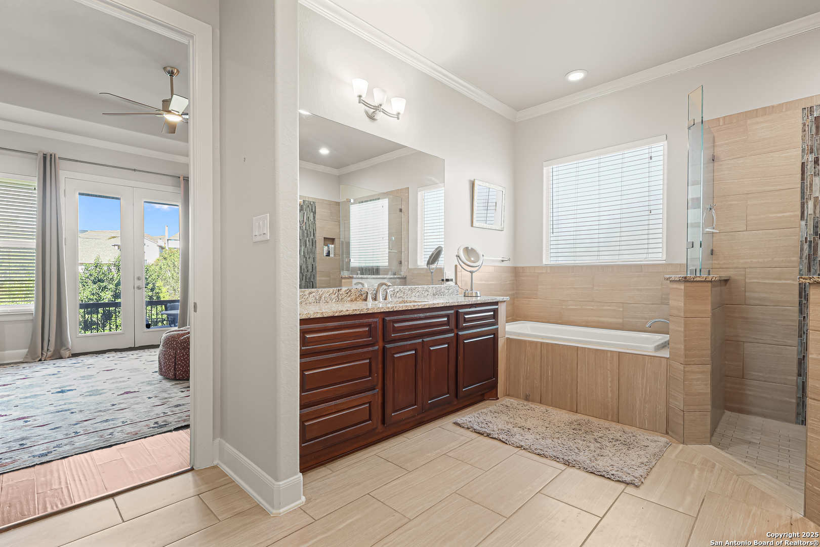919 Sutters Rim San Antonio, TX 78258 - Photo 12 of 27 a bathroom with a granite countertop sink a mirror and a bathtub