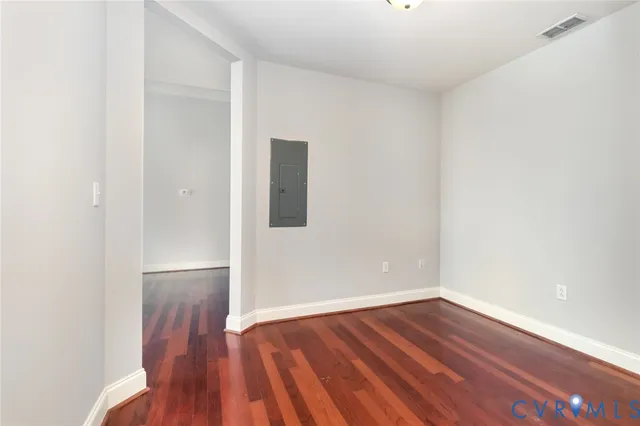 a view of an empty room with wooden floor