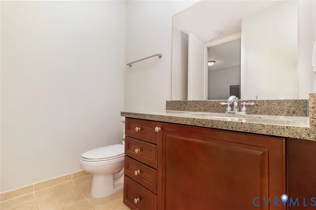 a bathroom with a granite countertop sink a toilet and a mirror