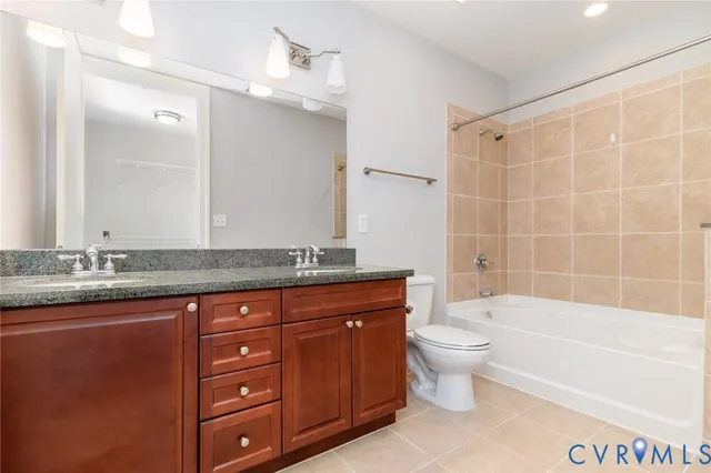 a bathroom with a granite countertop toilet a sink and a bathtub
