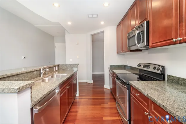 a kitchen with stainless steel appliances granite countertop a sink stove and cabinets