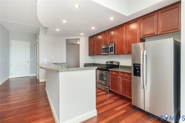 a kitchen with stainless steel appliances granite countertop a refrigerator stove top oven and sink