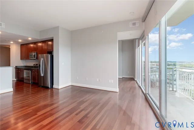 wooden floor in an empty room with a kitchen