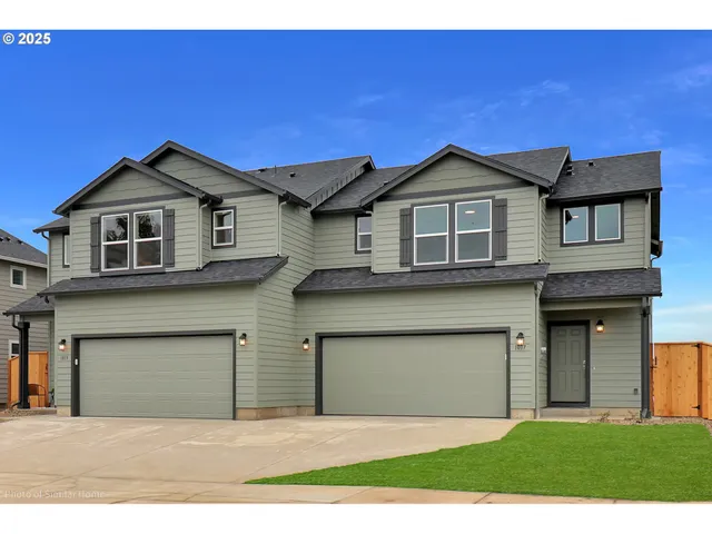 a front view of a house with yard and garage