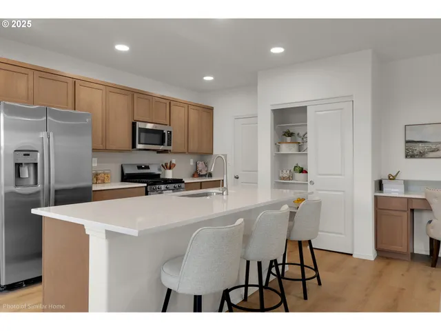 a kitchen with stainless steel appliances a microwave sink and refrigerator