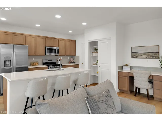 a kitchen with kitchen island a stove top oven a sink a counter top space and cabinets