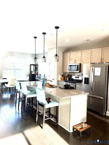 a kitchen with a table chairs refrigerator and a window