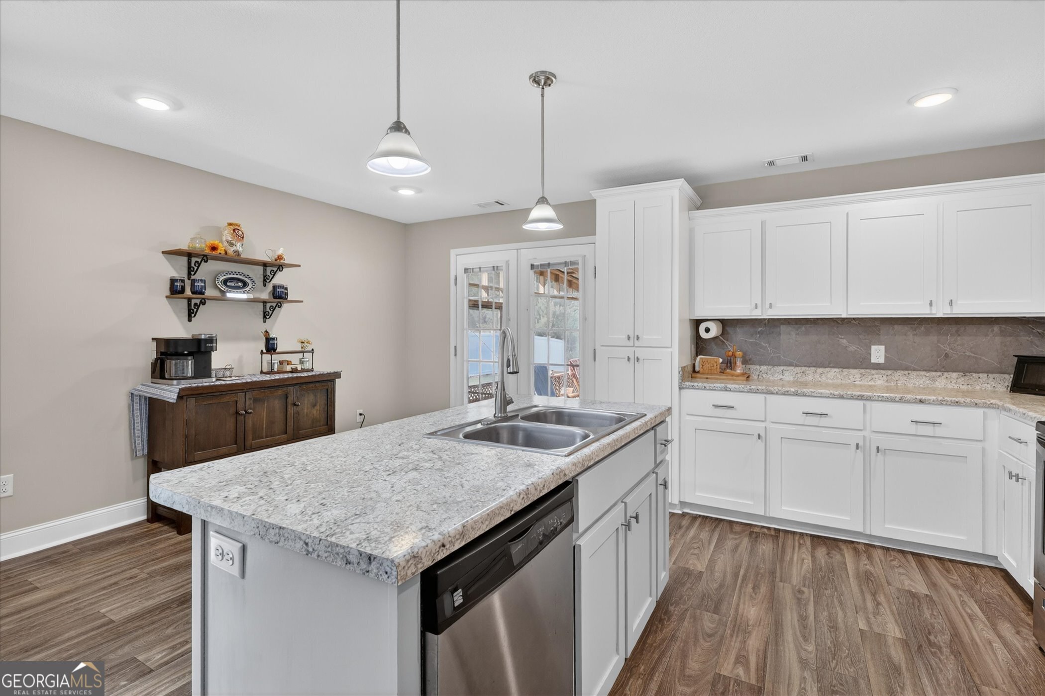 164 Stonebrook Way Statesboro, GA 30458 - Photo 15 of 46 a kitchen with a stove a sink a kitchen island with wooden floor and cabinets