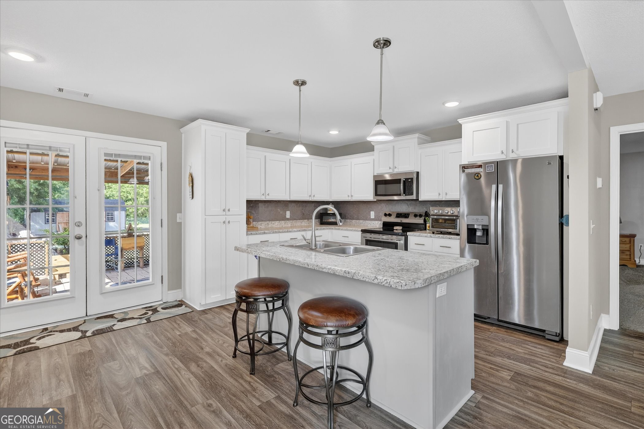 164 Stonebrook Way Statesboro, GA 30458 - Photo 17 of 46 a kitchen with stainless steel appliances granite countertop a table chairs refrigerator and microwave