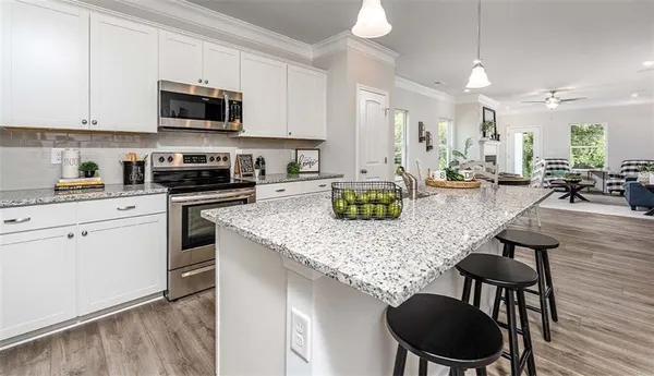 a kitchen with sink a stove and chairs