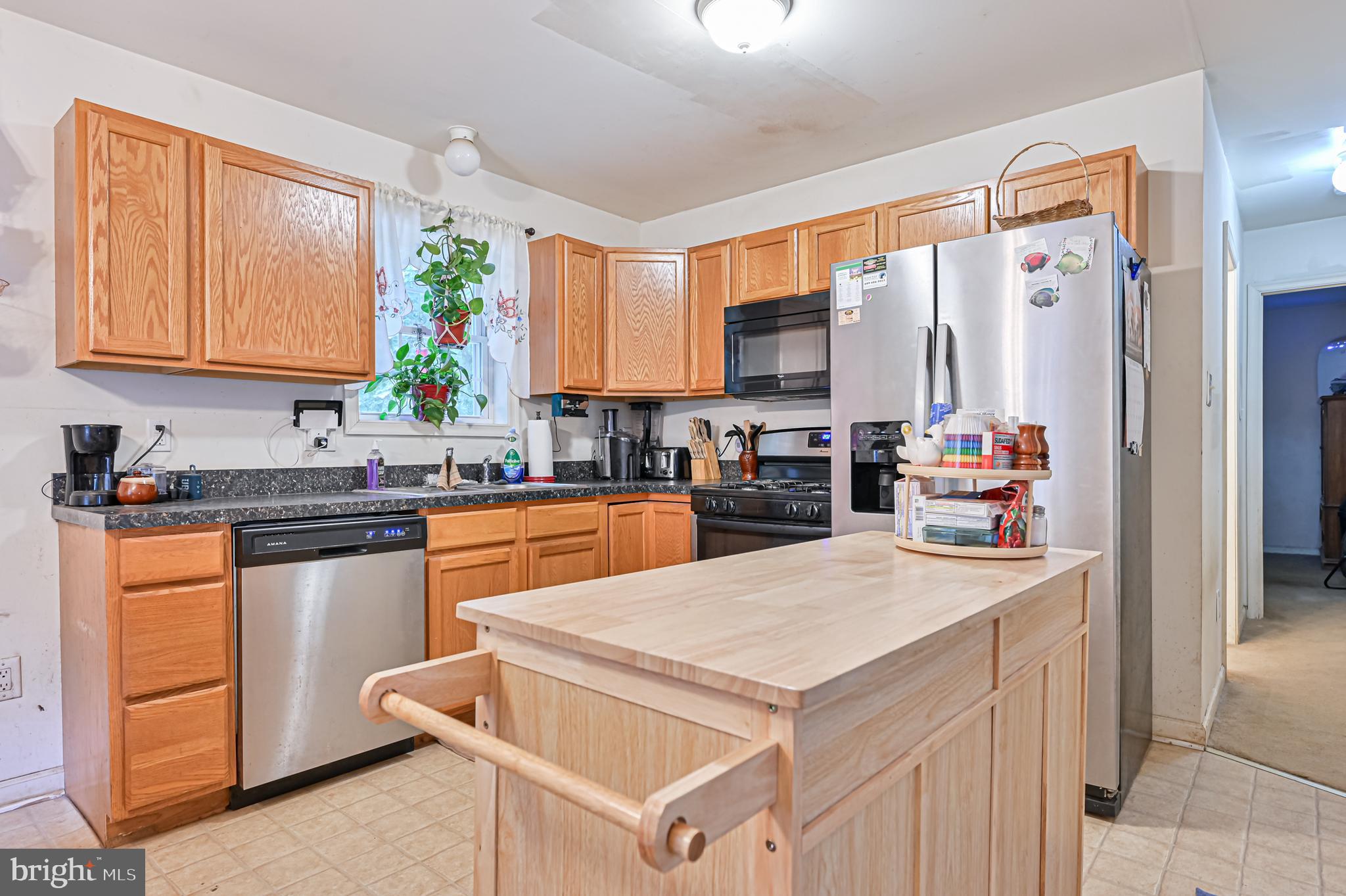 421 Evergreen Road Millville, NJ 08332 - Photo 2 of 26 a kitchen with stainless steel appliances kitchen island granite countertop a refrigerator a sink dishwasher and white cabinets with wooden floor