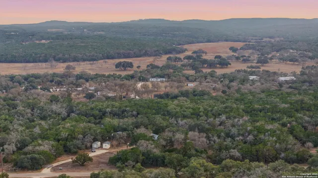 a view of a barn in the middle of a forest