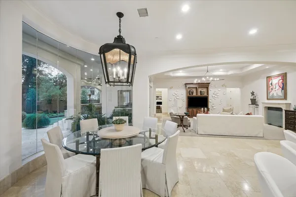 a living room with furniture a fireplace and a chandelier