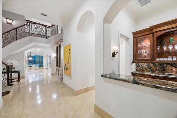 a view of staircase with lots of frames on wall and a chandelier