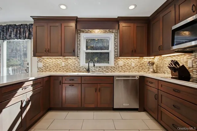 a kitchen with stainless steel appliances granite countertop a sink stove and cabinets