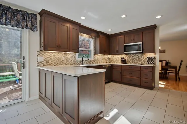 a kitchen with stainless steel appliances granite countertop a stove a sink and a refrigerator