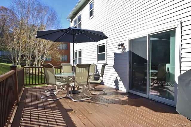 a view of a patio with a table and chairs under an umbrella