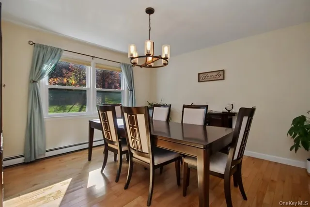 a dining room with furniture a chandelier and wooden floor