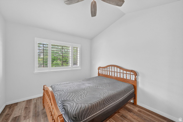 1464 990 West Provo, UT 84601 - Photo 19 of 41 Vaulted ceiling bedroom featuring wood-finish flooring, a three-panel window with plantation shutters, and a ceiling fan