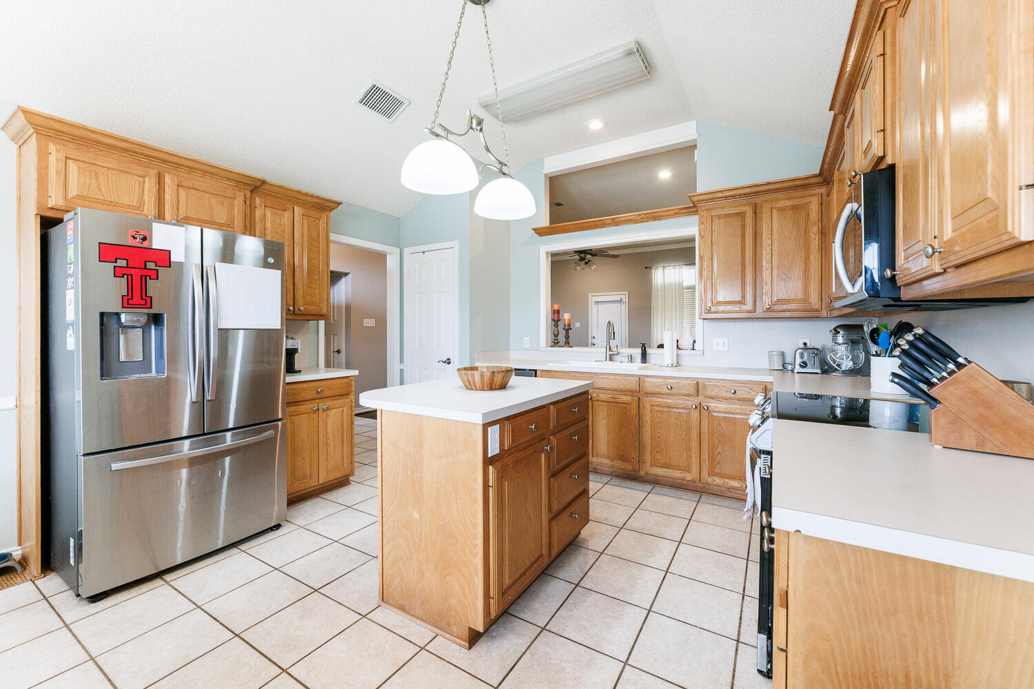 5504 101st Street Lubbock, TX 79424 - Photo 11 of 50 a kitchen with stainless steel appliances granite countertop a refrigerator a sink dishwasher and a stove with a dining table