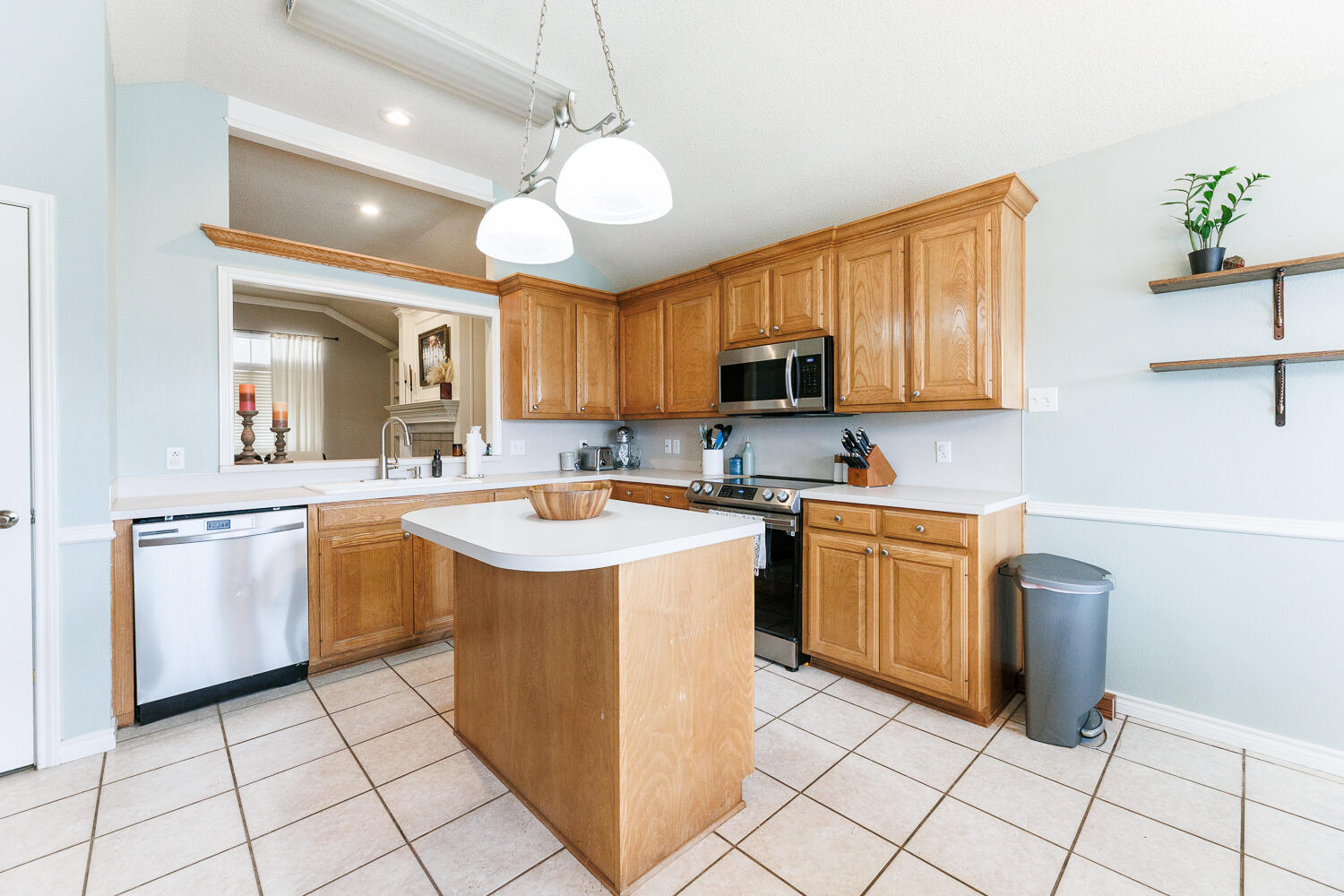 5504 101st Street Lubbock, TX 79424 - Photo 12 of 50 a kitchen with cabinets a sink a stove and a refrigerator