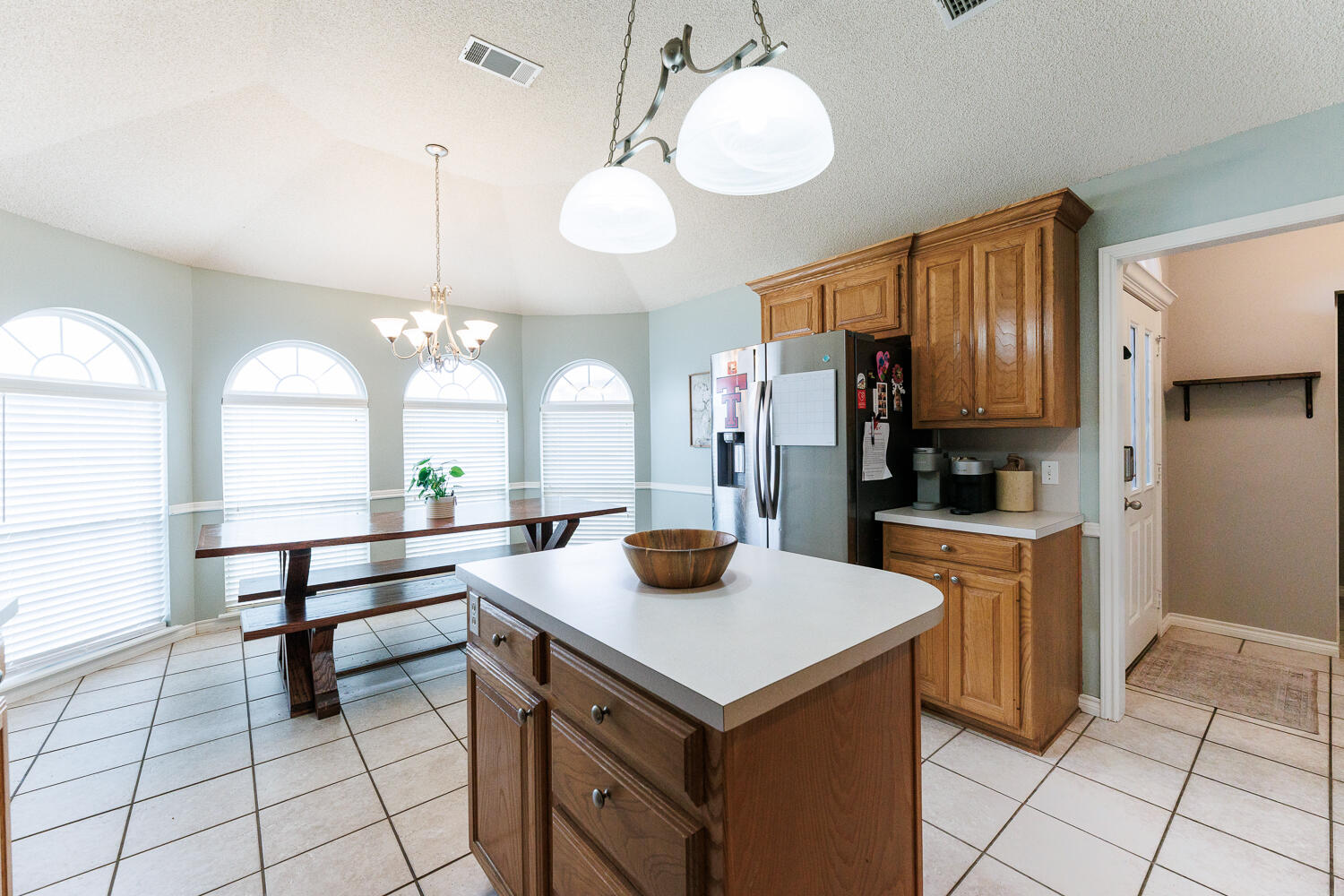 5504 101st Street Lubbock, TX 79424 - Photo 13 of 50 a kitchen with a refrigerator a sink and dishwasher with wooden floor
