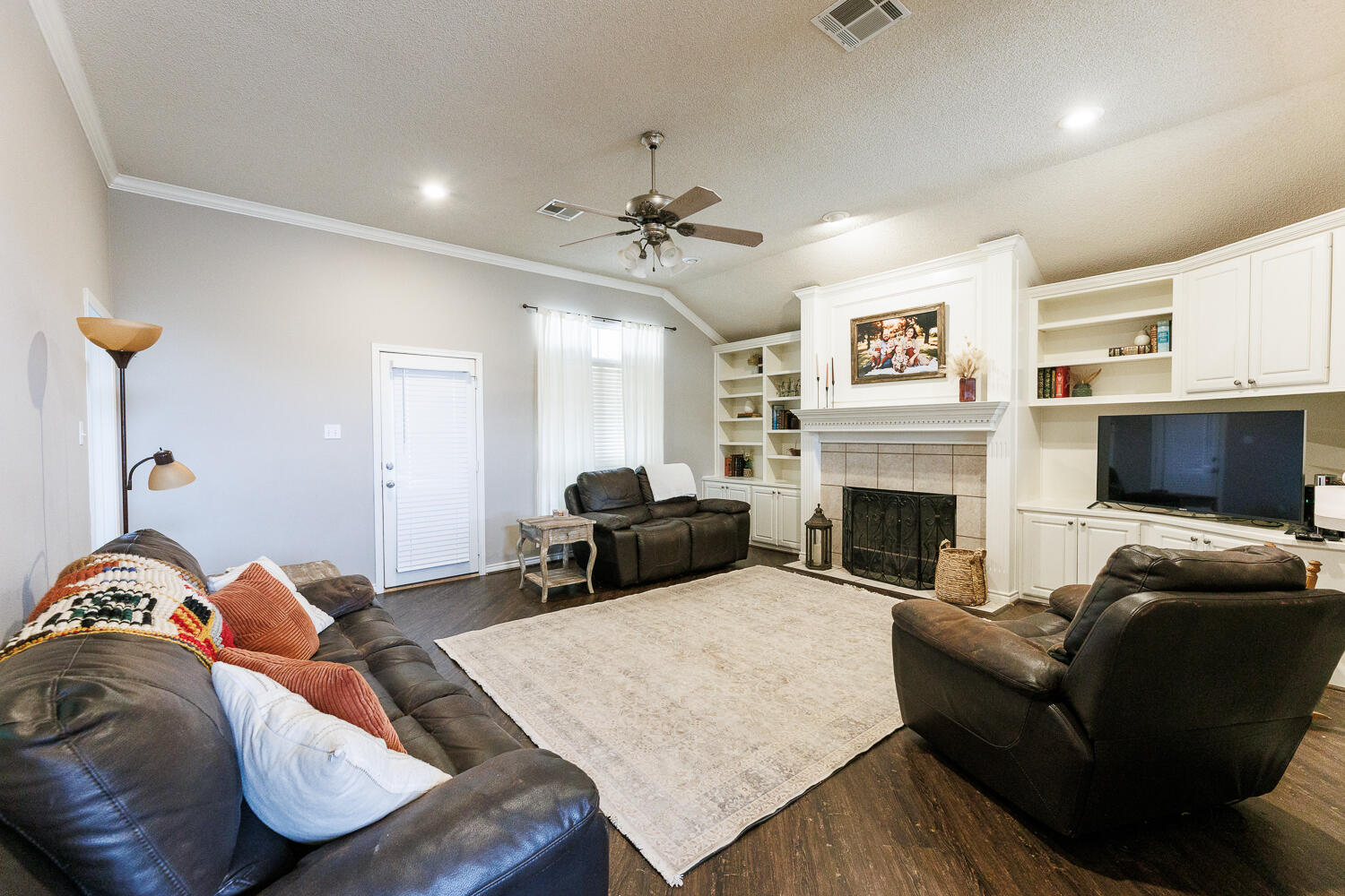 5504 101st Street Lubbock, TX 79424 - Photo 18 of 50 a living room with furniture a flat screen tv and a fireplace