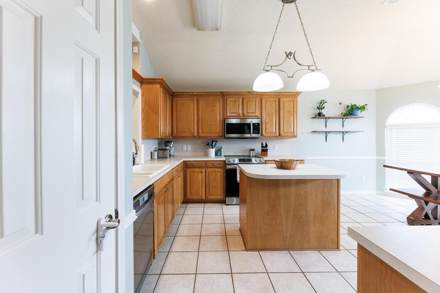 5504 101st Street Lubbock, TX 79424 - Photo 6 of 50 a kitchen with stainless steel appliances a sink a stove a refrigerator cabinets and a window