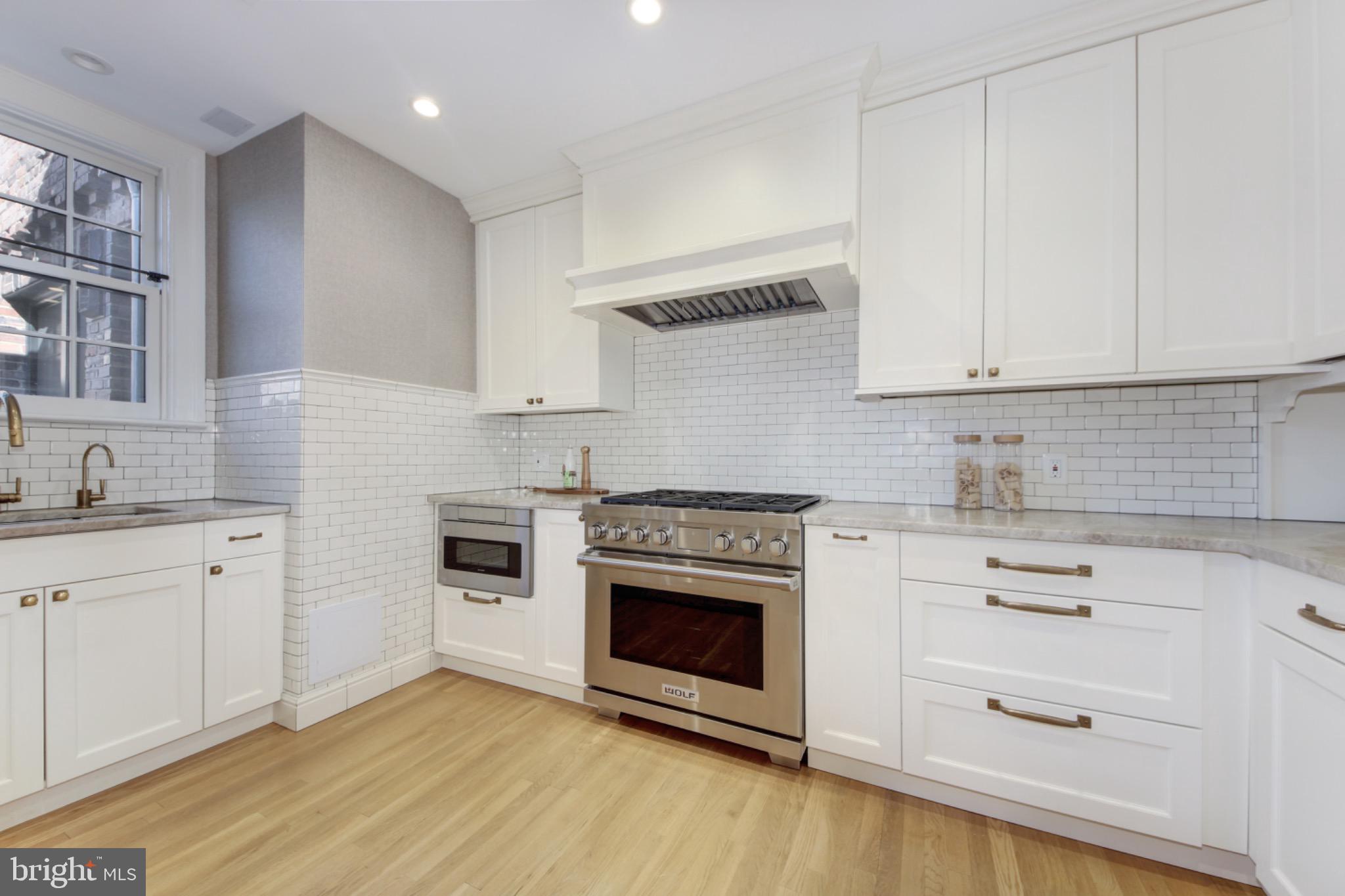 3000 Tilden Street Northwest, Unit 501I Washington, DC 20008 - Photo 12 of 48 a kitchen with cabinets stainless steel appliances and wooden floor