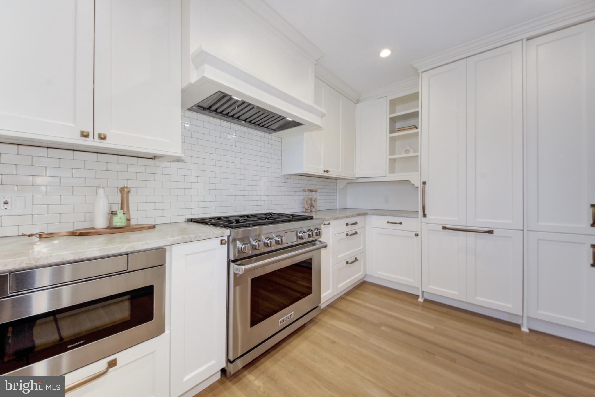 3000 Tilden Street Northwest, Unit 501I Washington, DC 20008 - Photo 14 of 48 a kitchen with cabinets wooden floor and stainless steel appliances