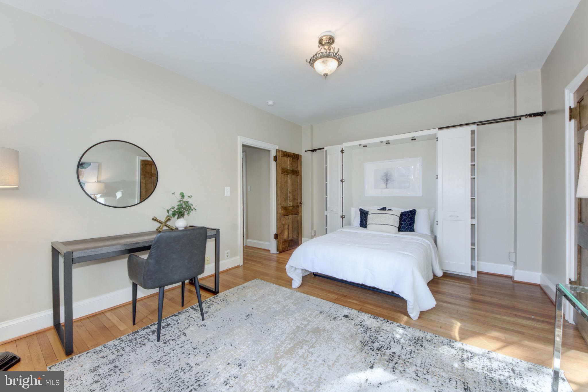 3000 Tilden Street Northwest, Unit 501I Washington, DC 20008 - Photo 19 of 48 a spacious bedroom with a bed a mirror and a table