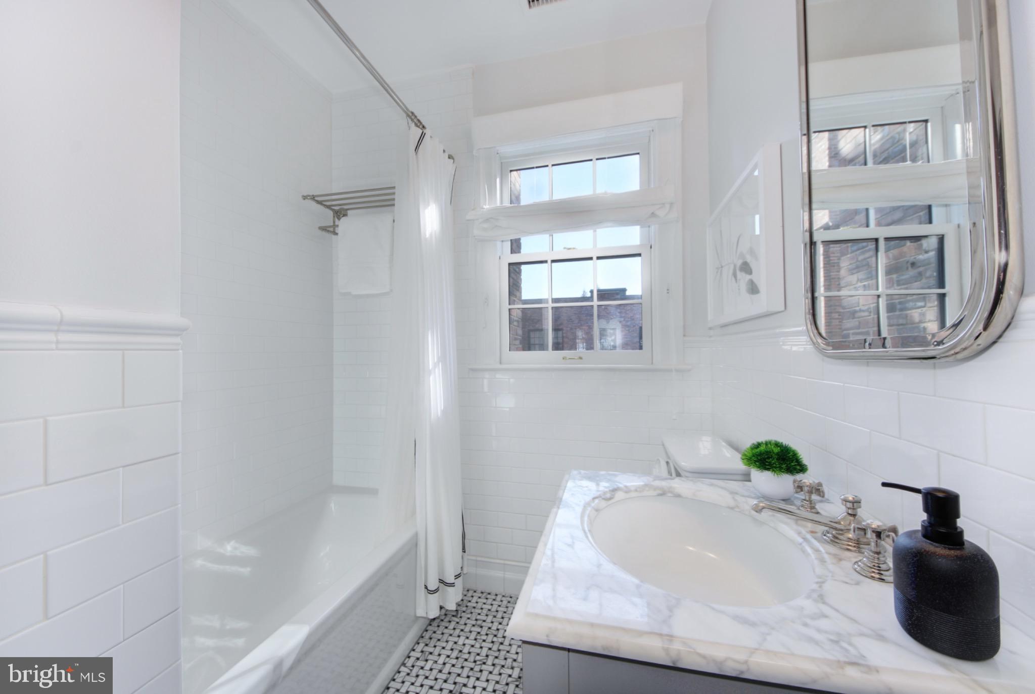 3000 Tilden Street Northwest, Unit 501I Washington, DC 20008 - Photo 26 of 48 a bathroom with a tub sink and mirror