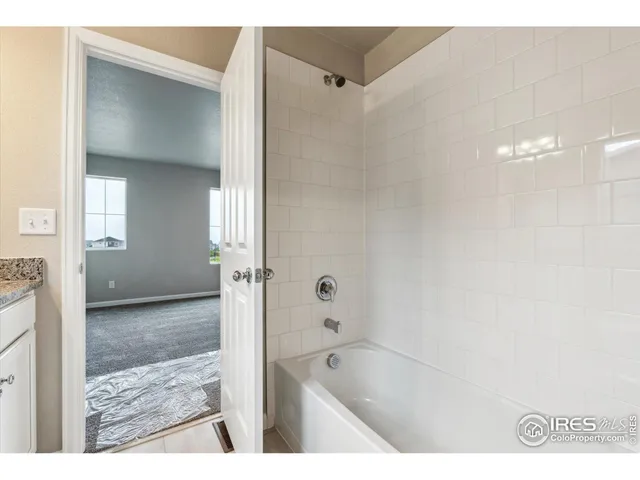 a bathroom with a tub shower and sink