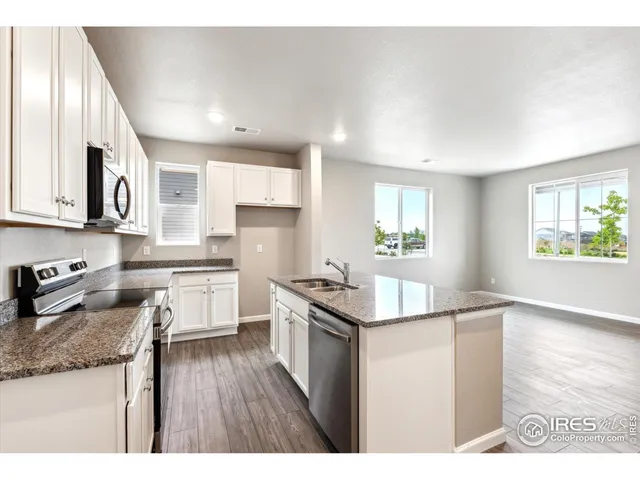 a kitchen with granite countertop a stove and cabinets