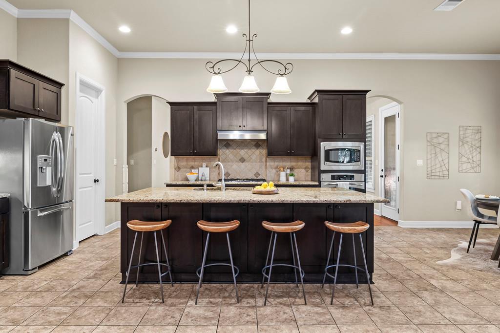 210 Mickelson Lane Georgetown, TX 78628 - Photo 12 of 39 a kitchen with stainless steel appliances granite countertop a sink and a refrigerator