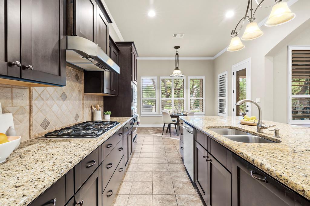 210 Mickelson Lane Georgetown, TX 78628 - Photo 14 of 39 a kitchen with granite countertop a sink stove and cabinets