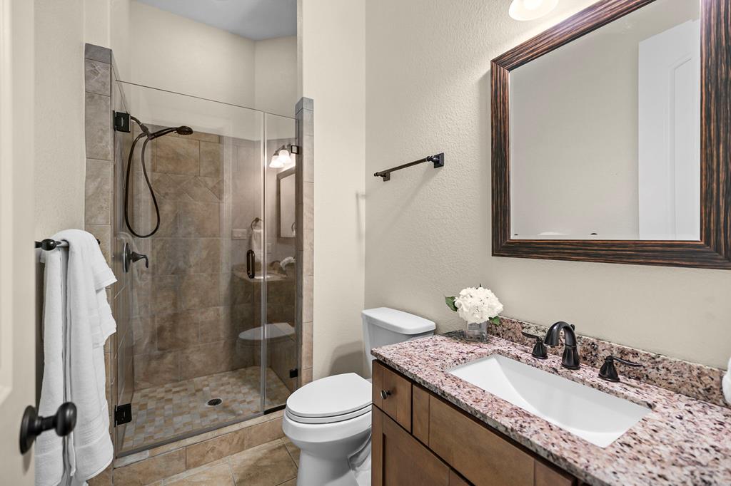 210 Mickelson Lane Georgetown, TX 78628 - Photo 22 of 39 a bathroom with a granite countertop sink toilet and shower