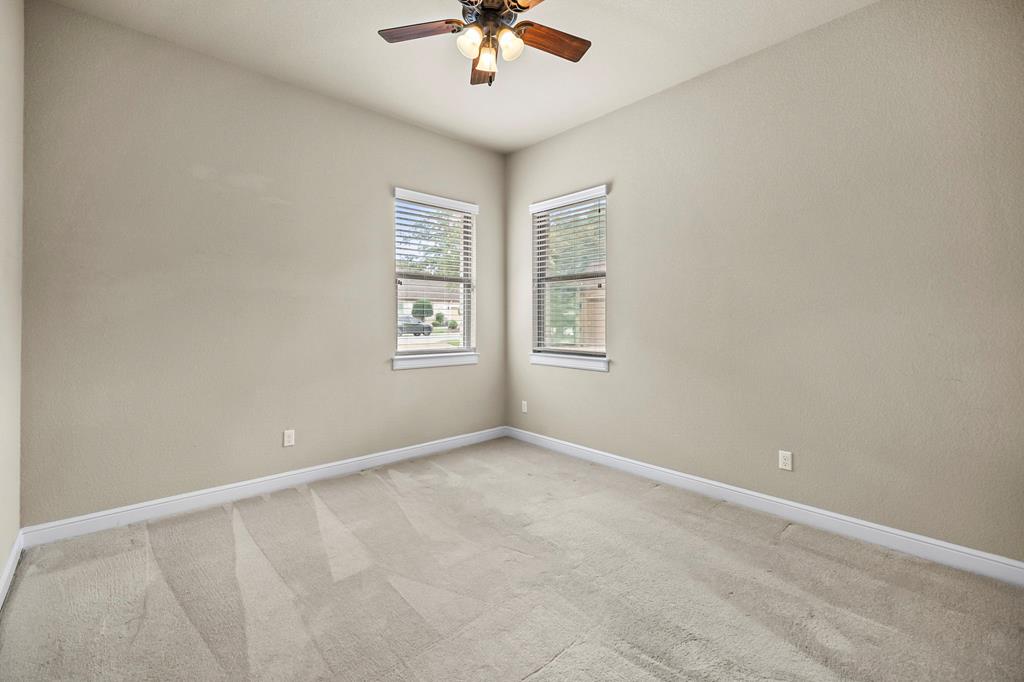 210 Mickelson Lane Georgetown, TX 78628 - Photo 23 of 39 an empty room with windows and ceiling fan