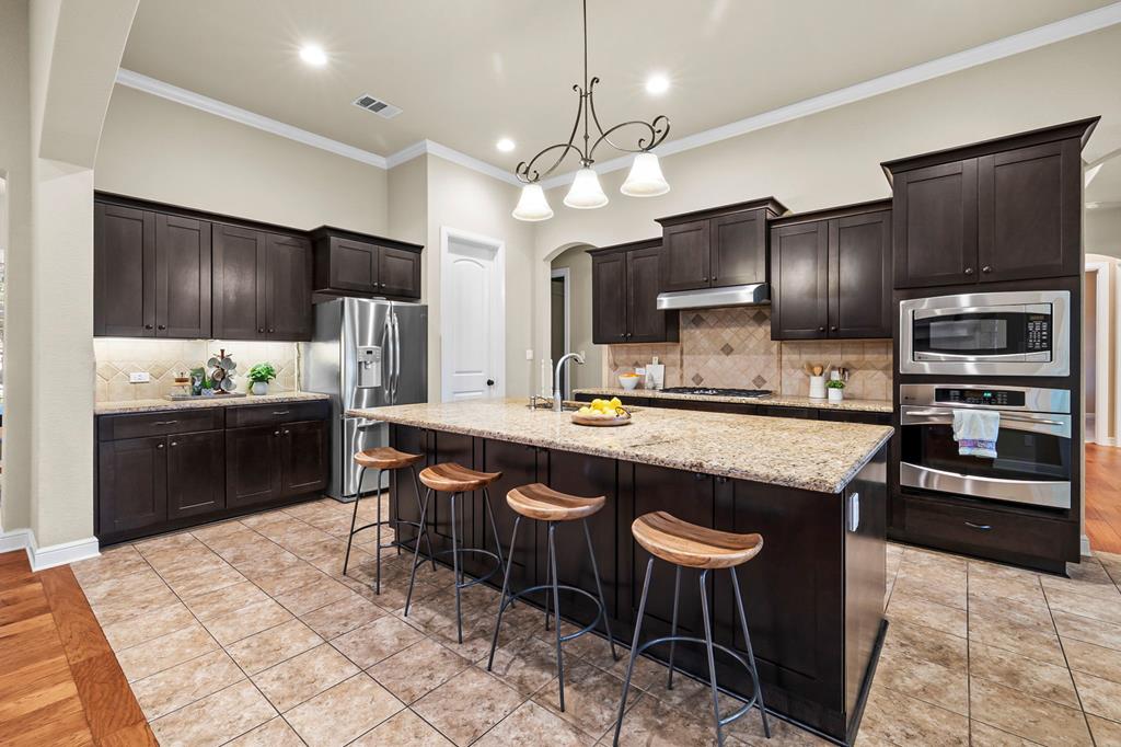 210 Mickelson Lane Georgetown, TX 78628 - Photo 4 of 39 a kitchen with stainless steel appliances granite countertop counter space a sink refrigerator and cabinets