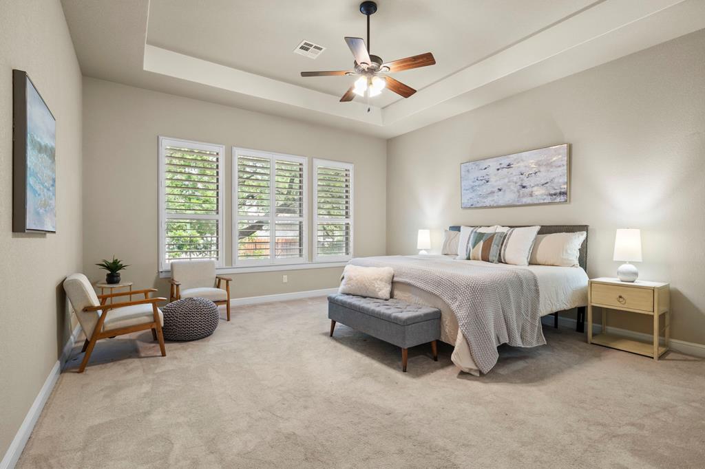 210 Mickelson Lane Georgetown, TX 78628 - Photo 5 of 39 a spacious bedroom with a bed a couch and a chandelier