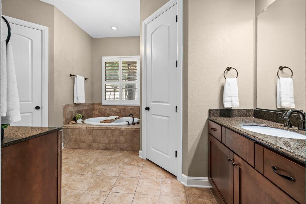 210 Mickelson Lane Georgetown, TX 78628 - Photo 8 of 39 a spacious bathroom with a granite countertop tub sink and mirror