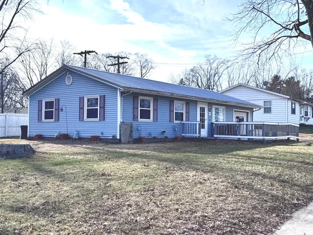 a view of a yard in front of a house with large windows