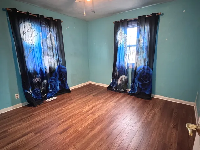 an empty room with closet and wooden floor