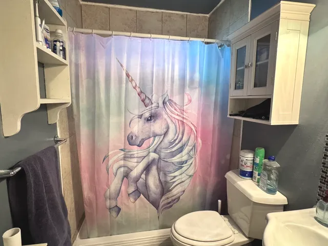 a white toilet sitting next to a bathroom sink and a mirror