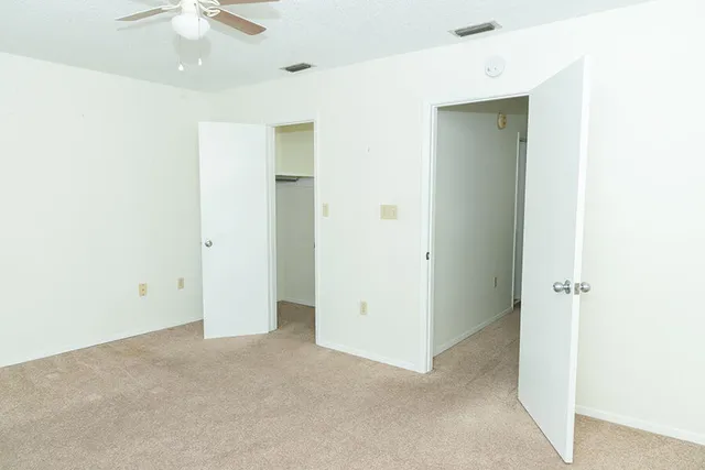 a view of an empty room with a ceiling fan