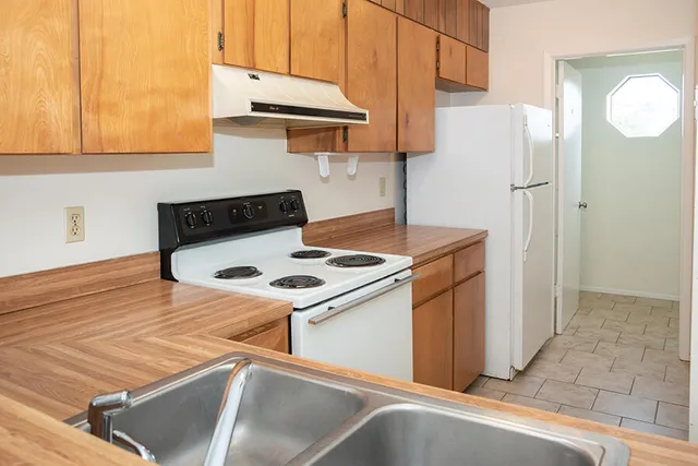a kitchen with stainless steel appliances granite countertop a refrigerator and a stove