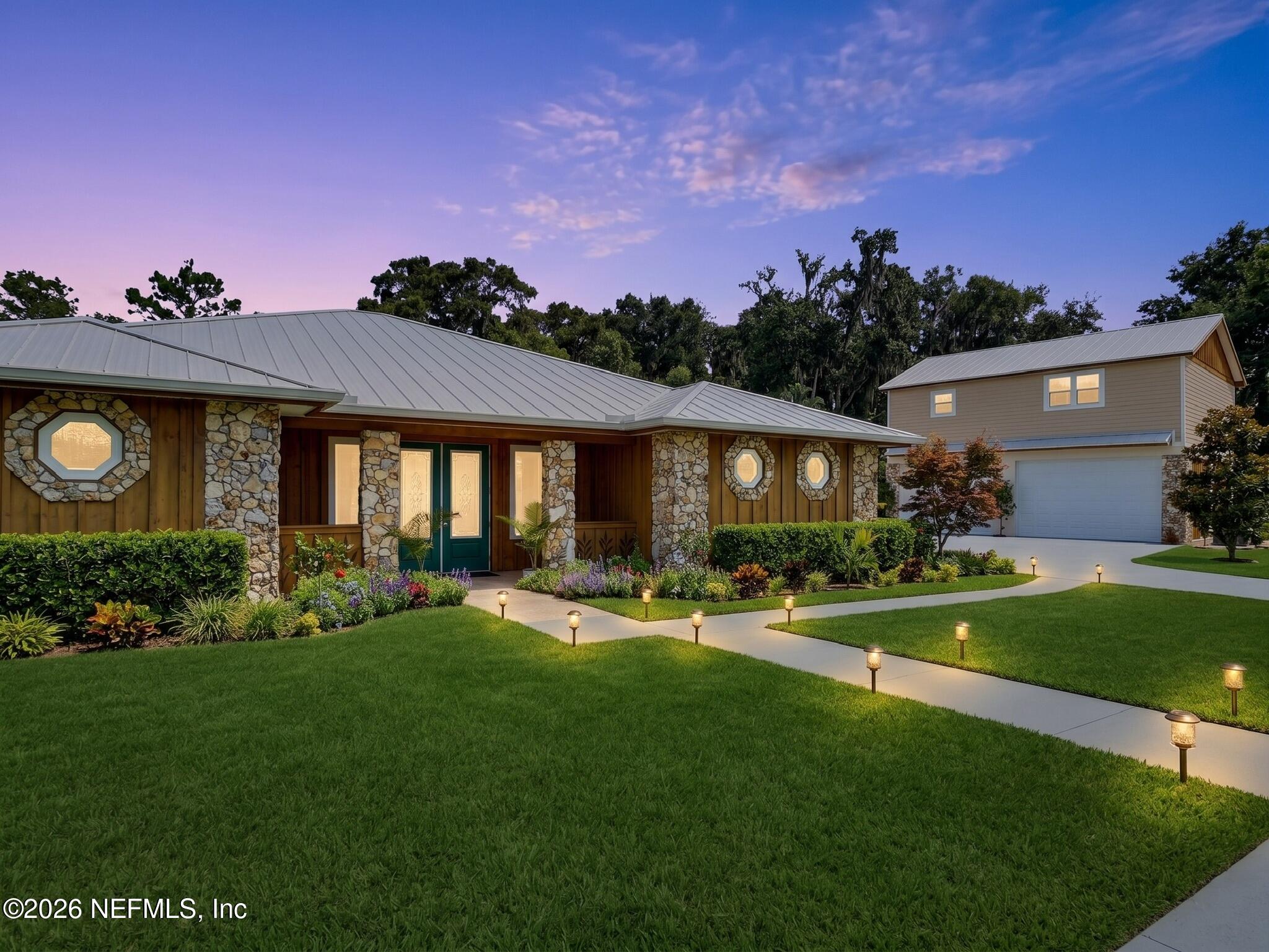 159 Mays Cove Road East Palatka, FL 32131 - Photo 4 of 62 a front view of a house with a garden and outdoor seating