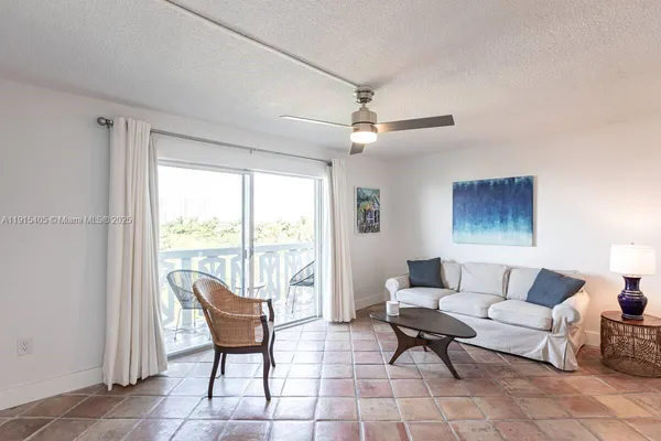 a living room with furniture and a floor to ceiling window